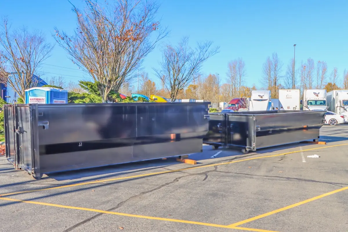 Professional dumpster rental service with roll-off container on residential driveway in Tysons